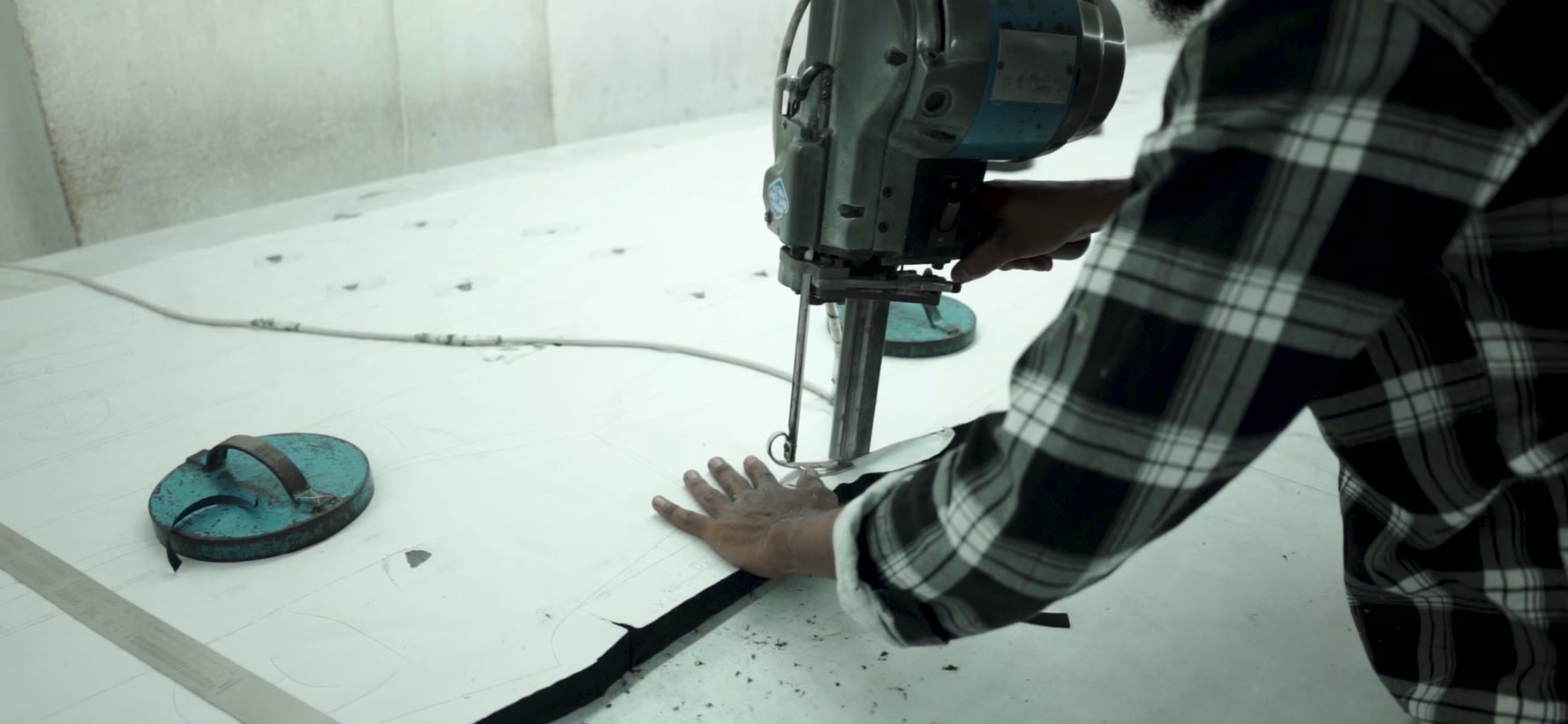 The band knife cutting through a stack of denim