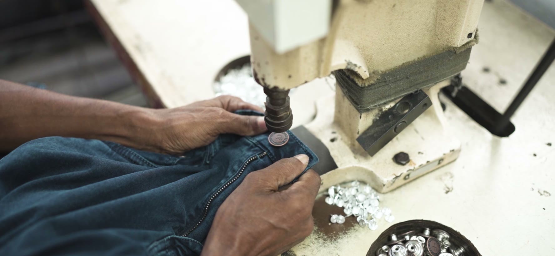 Button riveting on a waistband